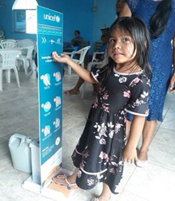 Criança em estação de higiene da UNICEF